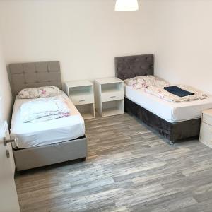 2 Betten in einem Zimmer mit Holzböden in der Unterkunft FMI20 Apartments 
