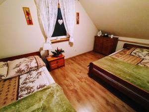 a bedroom with two beds and a window at Domek pod Orzechem in Kudowa-Zdrój +3 photos