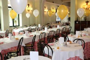 una fila de mesas con globos en las paredes en Hotel Milano Helvetia, en Riccione