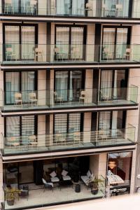an apartment building with chairs and tables on the balconies at The Londoner Hotel St. Julian's in St. Julianʼs