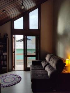 ein Wohnzimmer mit einem Sofa und einem großen Fenster in der Unterkunft Nascer do Sol - Edelweiss in Nova Petrópolis