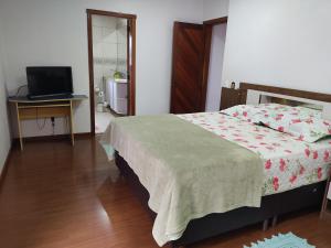 sypialnia z łóżkiem, biurkiem i telewizorem w obiekcie Nascer do Sol - Edelweiss w mieście Nova Petrópolis