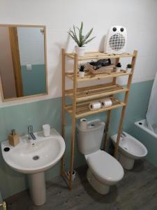 a bathroom with a toilet and a sink and a mirror at La fuente in Güéjar-Sierra