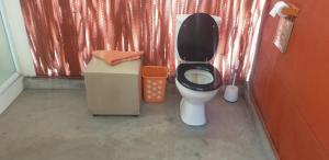 a bathroom with a toilet with a black lid at Paradise Camp Game Lodge in Groutfontein +53 photos