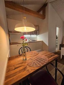 einen Holztisch mit einer Blumenvase darauf in der Unterkunft Studio Apartment Jož' 