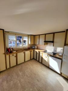 a large kitchen with white cabinets and windows at Chalet Lilo 4 Zimmer big View in Beatenberg
