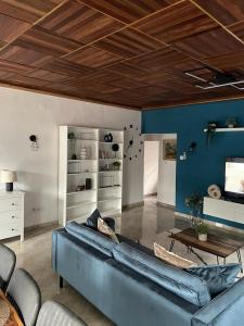 sala de estar con sofá azul y mesa en Mado Coliving - Studio Appart, Chambre coin cuisine, Chambre en Duala