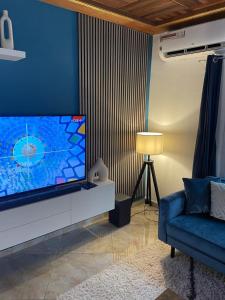 a living room with a large flat screen tv at Mado Coliving - Studio Appart, Chambre coin cuisine, Chambre in Douala