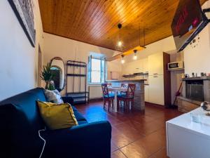 a living room with a blue couch and a table at Apt Finestra Sul Castello, Vista Lago Wi-Fi Gratis in Bracciano