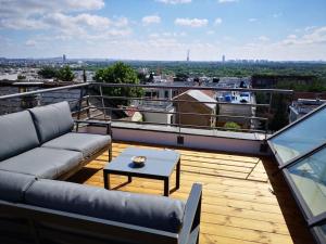 a balcony with a couch and a coffee table at Maison Exceptionnelle ! Vue tour Eiffel et Paris in Suresnes