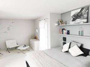 a white bedroom with a bed and a chair at Maison Exceptionnelle ! Vue tour Eiffel et Paris in Suresnes