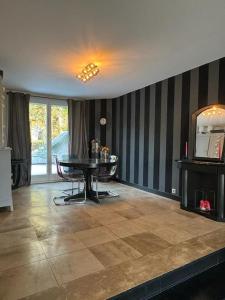 a living room with a table and a television at Maison Exceptionnelle ! Vue tour Eiffel et Paris in Suresnes