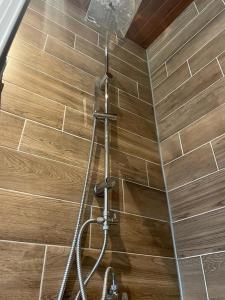 a shower in a bathroom with a tile wall at Mado Coliving - Studio Appart, Chambre coin cuisine, Chambre in Douala