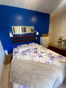 1 dormitorio con 1 cama con pared azul en La chiliere, en Ceyreste