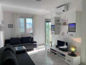 a living room with a couch and a tv at Apartment Tena in Novalja