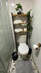 a bathroom with a toilet and a shelf with plants at Adalar Garden Bungalov in Kartepe