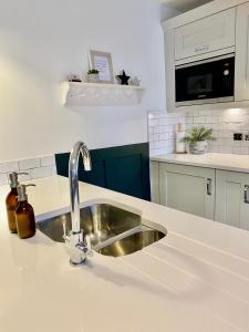 a kitchen counter with a sink in a kitchen at Boutique Chapel Apartment within City Walls in Chester +9 photos