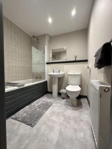 a bathroom with a toilet and a sink and a tub at Waterside View Apartment in Inverness