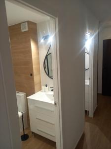 ein Badezimmer mit einem weißen Waschbecken und einem Spiegel in der Unterkunft Sea View Luxury Apartment Victoria in Torrevieja