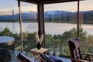 Cette chambre dispose d'une grande fenêtre offrant une vue sur le lac. dans l'établissement Drømmehytta på Senja, à Tranøya