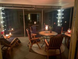 a living room with a table and chairs and a room with a balcony at Drømmehytta på Senja in Tranøya