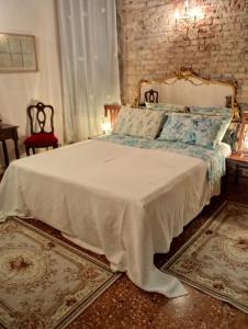 a bed in a bedroom with a brick wall at San Polo Home in Venice