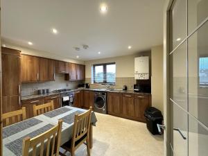 a kitchen with a table and a dining room at Waterside View Apartment in Inverness