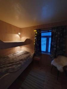 une petite chambre avec un lit et une fenêtre dans l'établissement Drømmehytta på Senja, à Tranøya