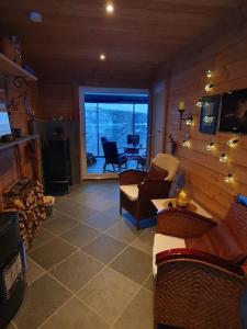 Elle comprend un salon doté de meubles et d'une grande fenêtre. dans l'établissement Drømmehytta på Senja, à Tranøya