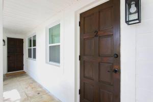 西棕榈滩Newly Renovated 1BR apartment in the heart of WPB的一条空的走廊,有门和窗户