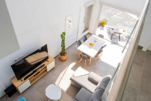 a living room with a couch and a tv and a table at NUEVA: Casa La Hondura in Las Eras