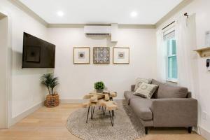 a living room with a couch and a tv at Lovely 1 Bedroom - Walk to Waterfront in West Palm Beach