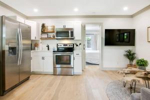 a kitchen with white cabinets and stainless steel appliances at Lovely 1 Bedroom - Walk to Waterfront in West Palm Beach