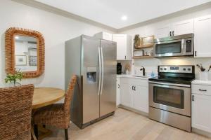 a kitchen with a table and a stainless steel refrigerator at Lovely 1 Bedroom - Walk to Waterfront in West Palm Beach +41 photos