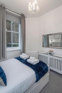 a bedroom with a bed and a mirror and a window at Beautiful 1 Bed Flat close to Regents Park in London