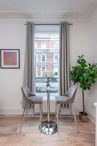 a room with two chairs and a table and a window at Beautiful 1 Bed Flat close to Regents Park in London