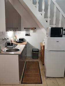 a kitchen with a sink and a white refrigerator at Apartman Rosé in Eger