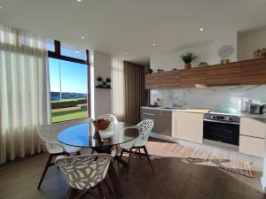 a kitchen with a glass table and chairs in a kitchen at Apartamento Mar & Sal in Mindelo