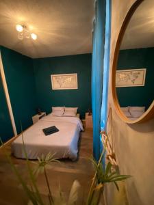 a bedroom with a bed and a round mirror at - Le backpacker - logement atypique et spacieux en résidence avec ascenseur in Nevers +5 photos