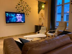 a living room with a couch and a flat screen tv at - Le backpacker - logement atypique et spacieux en résidence avec ascenseur in Nevers