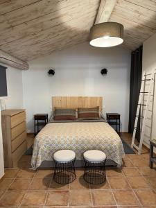 1 dormitorio con 1 cama con 2 mesas y 2 sillas en L'Atelier d'André, en Beaumes-de-Venise
