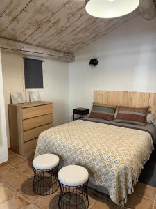 a bedroom with a bed with two chairs and a tv at L'Atelier d'André in Beaumes-de-Venise