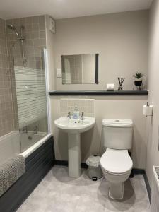 a bathroom with a toilet and a sink and a shower at Waterside View Apartment in Inverness