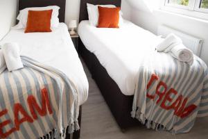two beds in a hotel room with towels on them at Central Cambridge, 2 Superking or 4 Single Beds, Parking & Garden, WORK CONTRACTOR LEISURE - QUARTZ in Chesterton