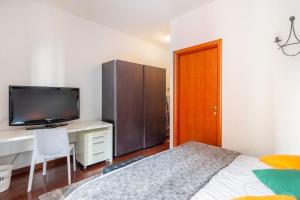 1 dormitorio con 1 cama y escritorio con TV en Modern apartment in Milano Centrale next to Metro M5 - Sarca 73, en Milán
