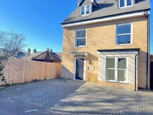 a brick house with a fence and a driveway at Central Cambridge, 2 Superking or 4 Single Beds, Parking & Garden, WORK CONTRACTOR LEISURE - QUARTZ in Chesterton