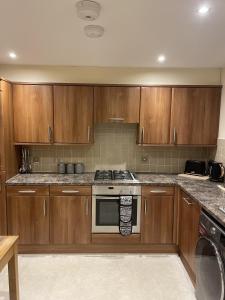 a kitchen with wooden cabinets and a stove top oven at Waterside View Apartment in Inverness