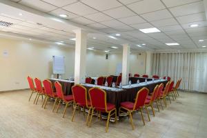 a conference room with a long table and red chairs at The Country Inn by Smart Haven in Kigali