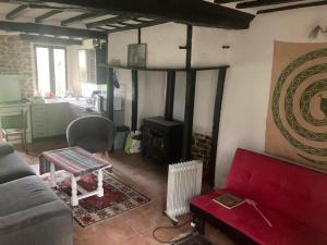 uma sala de estar com um sofá e um fogão em Petit Coin de Paradis Studio em Moyon