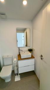 a bathroom with a toilet and a sink and a mirror at Son Serra Sea Coast Villa in Son Serra de Marina